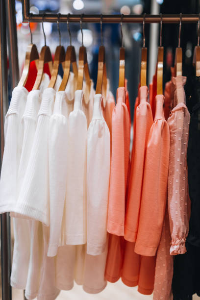 istock Pink white women's blouses hanging on a hanger in a row. 1475274180