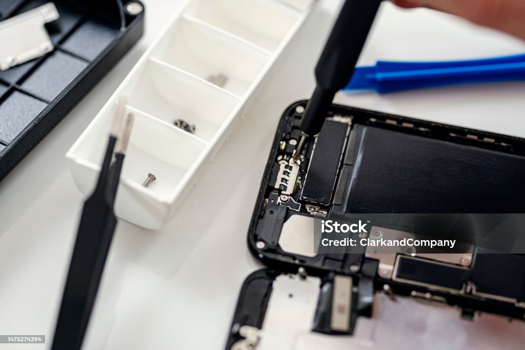 Smart Phone Repair Close-up of a technician fixing a modern smart phone. Ideal for illustrating the “right to repair” movement. Colour, horizontal format with some copy space. Accuracy Stock Photo