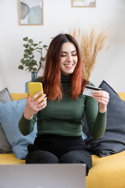 istock Happy woman using smartphone on sofa shopping online 1475274870