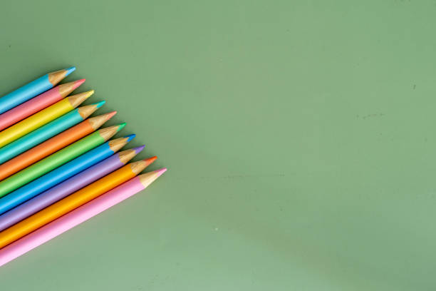 istock Pastel colored pencils, top view on green background, illustration concept, education and back to school 1475275325