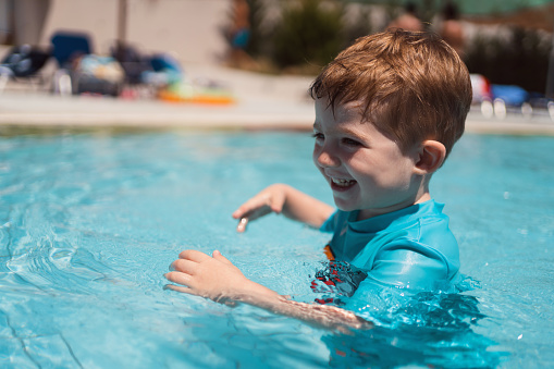 Toddler boy enjoying a day at the swimming pool.