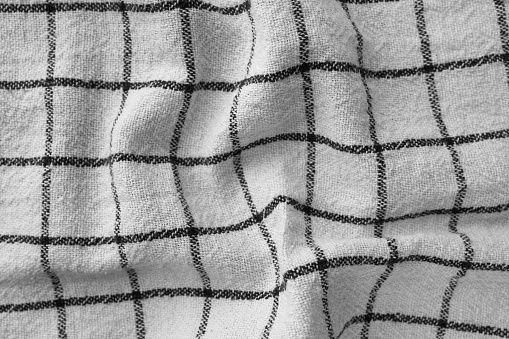 Classic black and white checkered kitchen towel texture. Crumpled fabric textile background with visible weave and thread detail. Ideal for web, print, packaging or for any other design project
