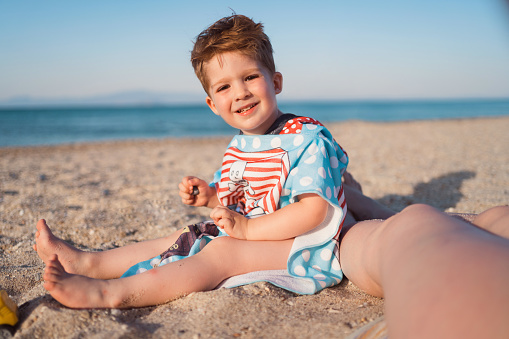Portrait of a toddler boy enjoying the day at the beach.
