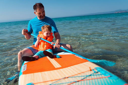 Father and son on a paddleboard.