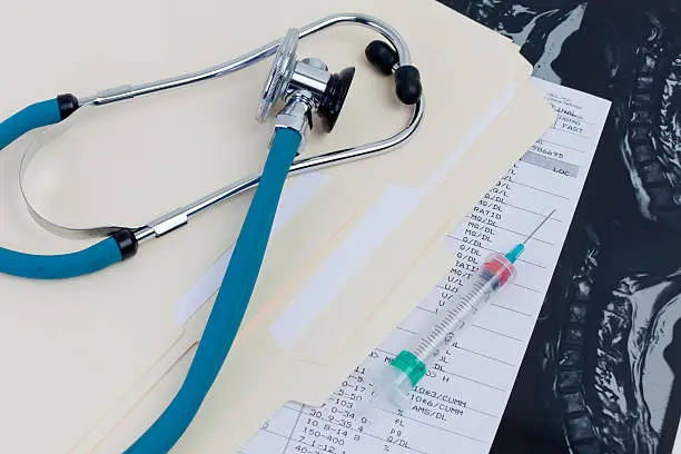 Medical Records & Stethoscope along with a syringe on a MRI exam