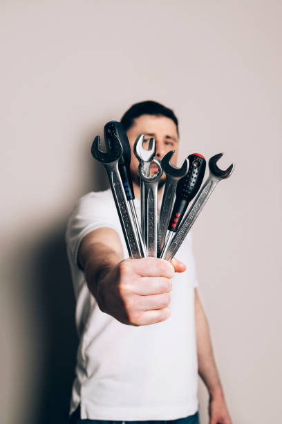 istock Man with bouquet of wrenches and screwdrivers 1475279743