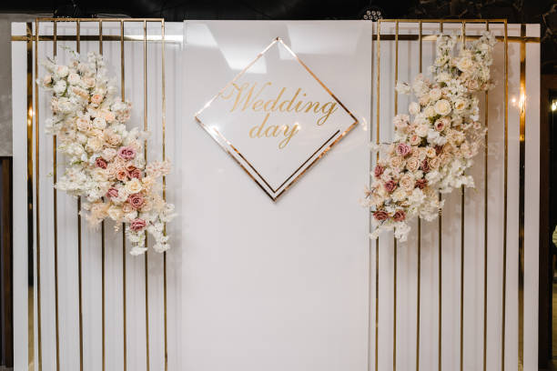 istock Arch with text wedding day. Wedding reception for luxury ceremony. Photo wall, arch decorated flowers and metal gold decor. Celebration wedding concept. Trendy decor for party in the banquet area. 1475280698