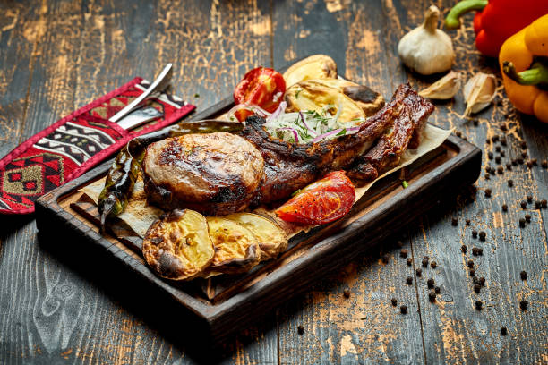 istock Pork steak on the bone, barbecued with vegetables on a wooden board. 1475281995