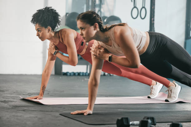istock Gym floor, health and exercise woman doing arm plank workout, performance training or core muscle building. Body self care, commitment and wellness for team, people or friends on fitness class ground 1475282803