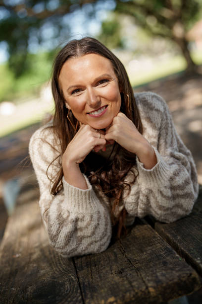 istock Happy young woman laying on her front on a table in the park 1475282943
