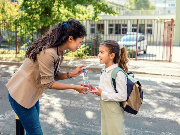 istock School child taking bottle of water from her mother 1475282988
