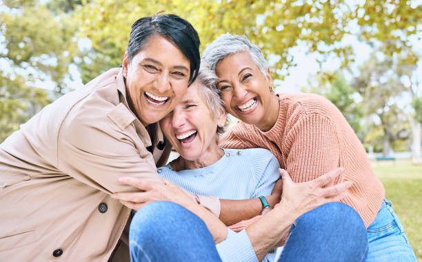 istock Retirement, women or laughing portrait in funny hug game, comic bonding or silly group activity in relax environment Smile, happy or elderly senior friends in nature park, grass garden or community 1475287715