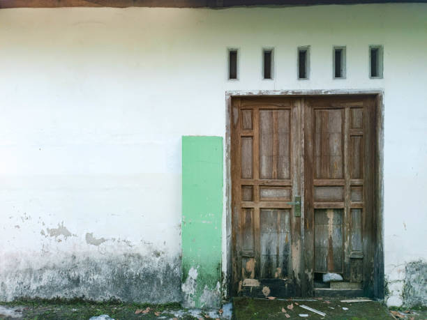 Traditional two wooden door with white wall. Kediri, East Java, Indonesia. October 09, 2022.