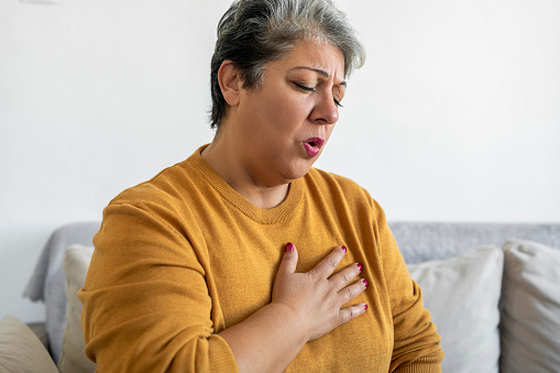 Mujer sosteniendo la mano dolor en el pecho, dificultad para respirar photo