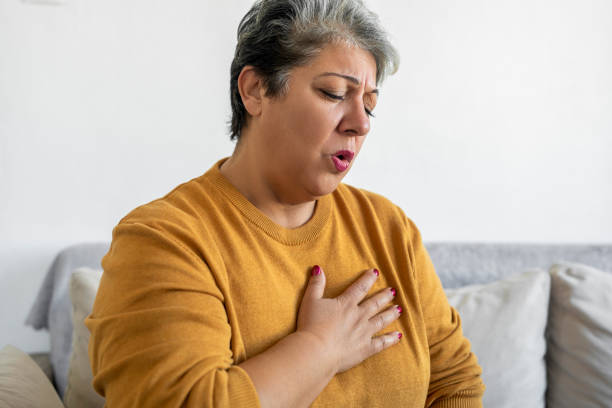 istock Woman hand holding chest pain, difficulty to breathe 1475292100