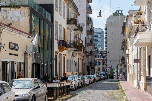 March 22, 2023: San Telmo neighborhood in Buenos Aires. Photo shows a street in the neighborhood with graffiti, tourists, and locals.