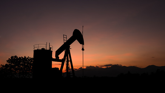 silhouette Oil well pump energy industrial machine for petroleum in the sunset background