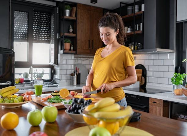 istock Young beautiful pregnant lady making various fruit smoothies in the home kitchen 1475300276
