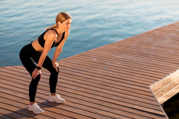 istock Middle Aged Female Athlete In Activewear Resting On Pier While Training Outdoor 1475307099