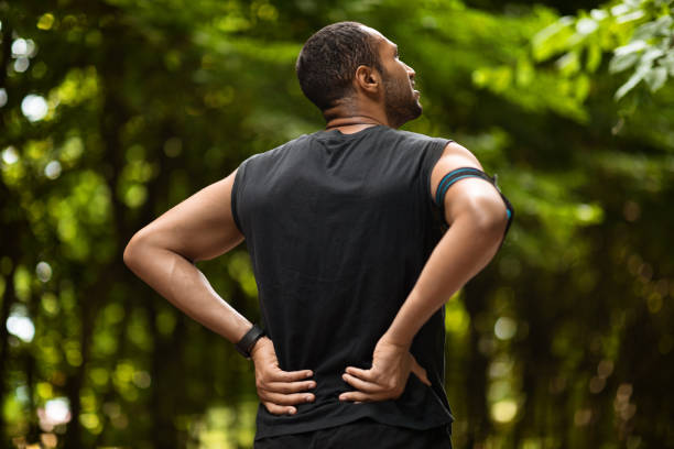 istock Back view of black sportsman touching sore zone on back 1475307176