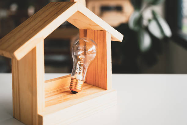 istock Light bulb with wood house on the table, a symbol for construction, Creative light bulb idea, power energy or business idea concept ecology, loan, mortgage, property or home. 1475308851
