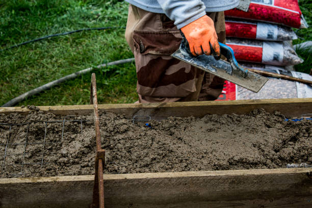 istock Bricklayer spreading concrete with a trowel and level to build a wall at a construction site 1475310830