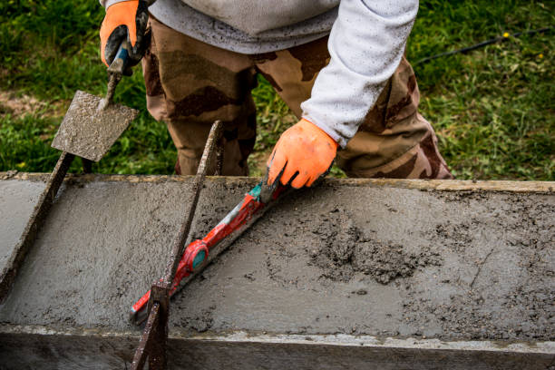 istock Bricklayer spreading concrete with a trowel and level to build a wall at a construction site 1475310891