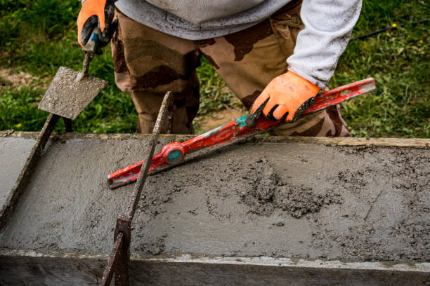 istock Bricklayer spreading concrete with a trowel and level to build a wall at a construction site 1475310919