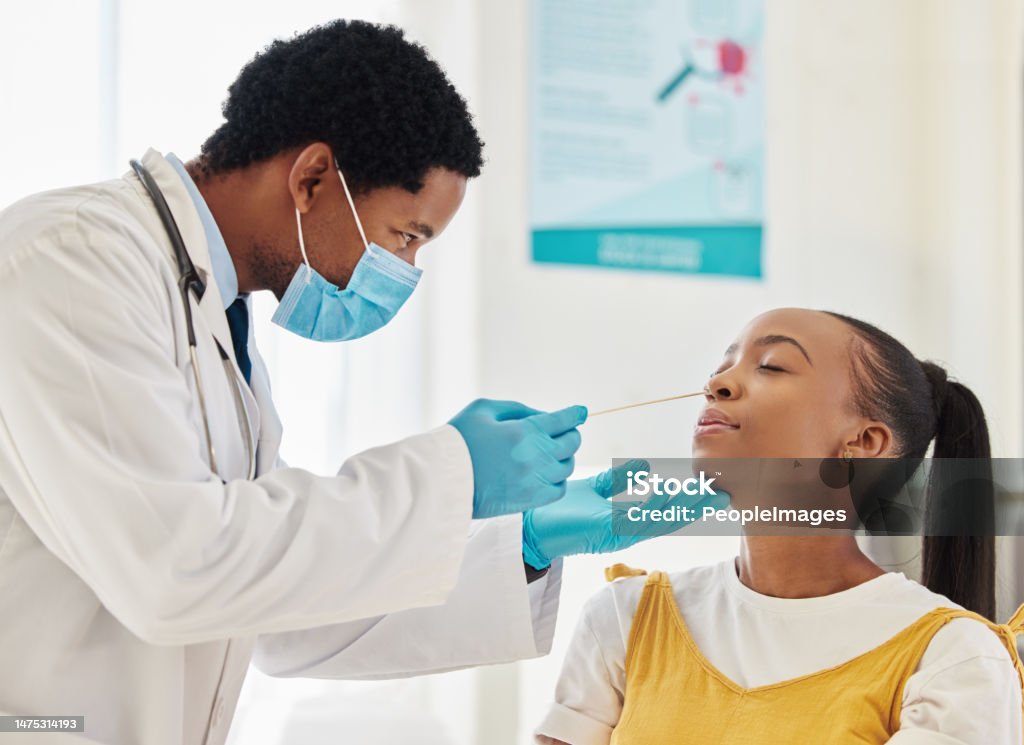 Doctor, black woman or covid swab test in hospital checkup, clinic wellness or bacteria virus control. Patient, cotton or nose with healthcare worker in disease sample, medical research or compliance Scientific Experiment Stock Photo