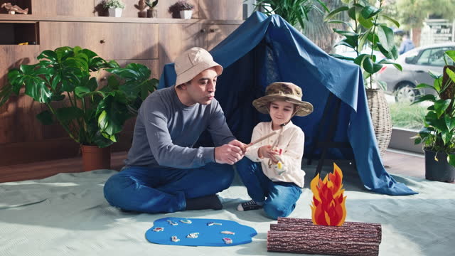 Father and toddler son playing camping game at home, concept for activities for activities at home for children