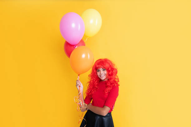 istock glad child with party balloon on yellow background 1475315923