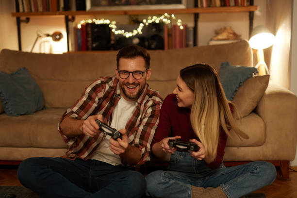 istock Young couple having fun at home playing video games 1475316865
