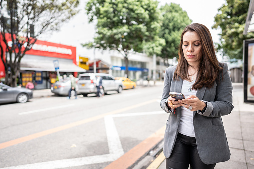 Mature woman using mobile phone on the city