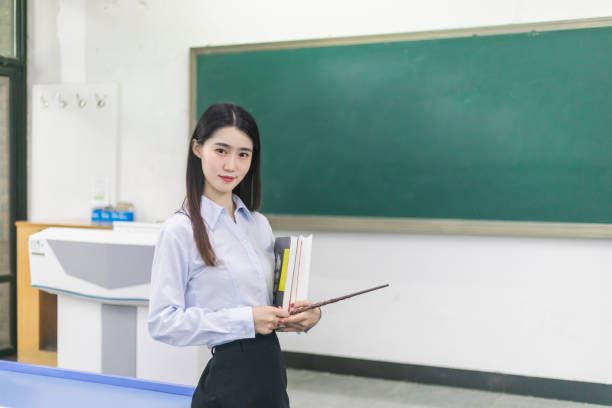 Secondary age schoolgirls in a discussion with their teacher in a classroom. Shallow focus is on the nearest girl. Adobe RGB 1998 profile.
