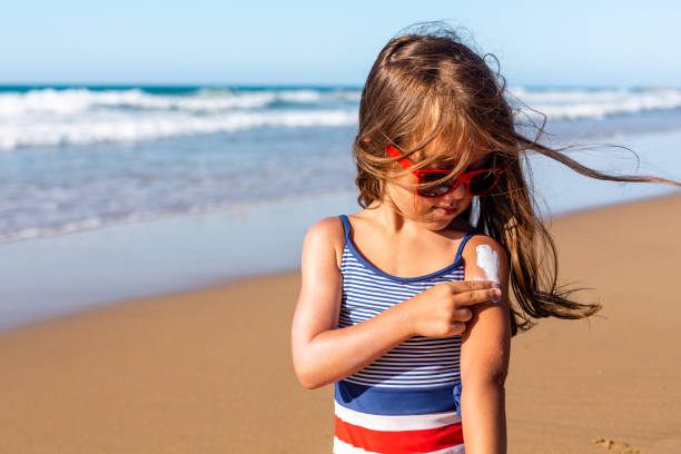 istock Little Girl applying sunscreen on the beach 1475322610