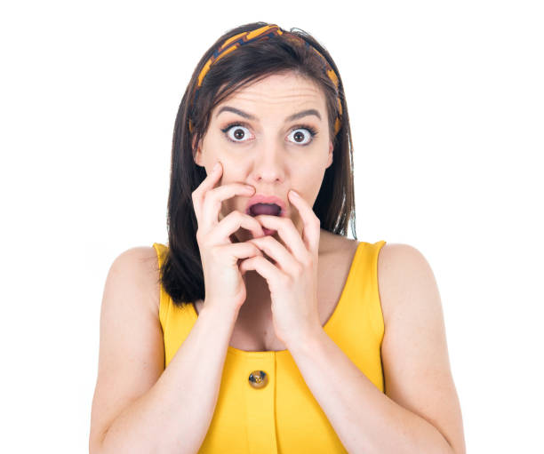 Scared girl biting fingernail,being terrible accident, isolated on white background. Frightened woman staring to you stock photo