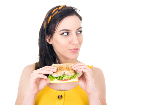 Close up young woman eating sandwich. Beautiful girl enjoying in fast food, delicious snack, isolated on white background. Studio shot