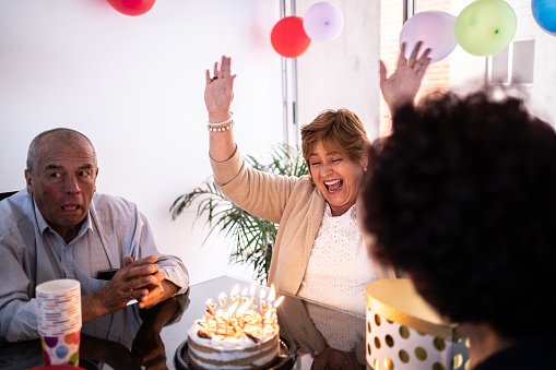 Mature woman commemorating her birthday party with her friends at home