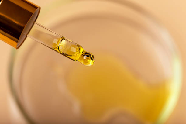 istock Dropper with yellow liquid over the petri dish close-up 1475324738