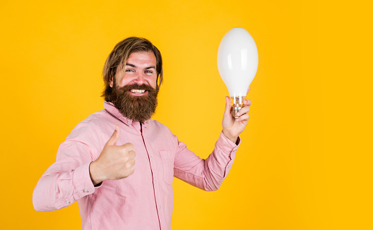 thumb up for success. Business idea and creativity symbol. bearded thinking man hold bulb. Energy saving. innovative idea and innovation. modern thinking. Solution to problem. new idea generator.