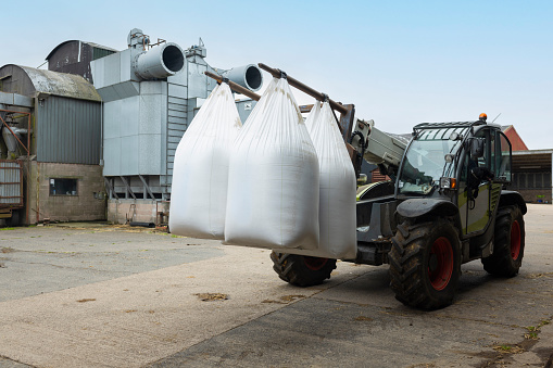 A shot of a forklift tractor lifting heavy-duty bulk bags of nitrogen sulphur fertiliser on a sustainable farm in Northumberland in northeast England.