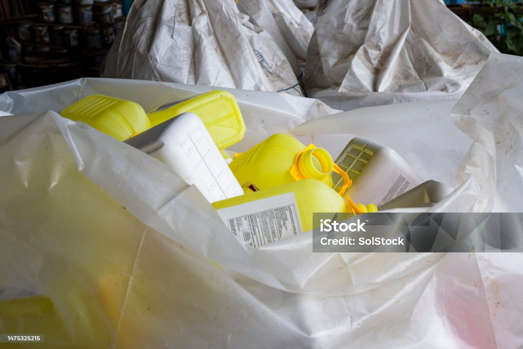 Recycling Plastics For A More Environmentally Friendly Farm Empty plastic container bottles are used for agricultural farming to store chemicals. The plastics are been collected and stored to be recycled after use. Garbage Bag Stock Photo
