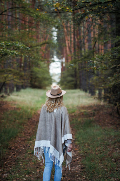 istock Woman walking in path in forest 1475326659