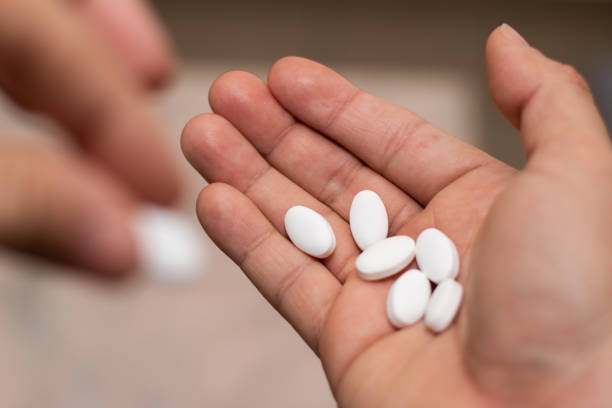 istock Close up hand taking medicine pill with selective focus 1475326758