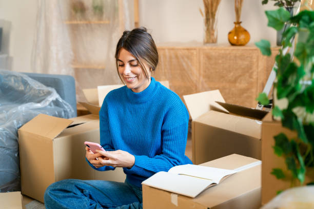 istock Smiling woman using smartphone at home 1475327381