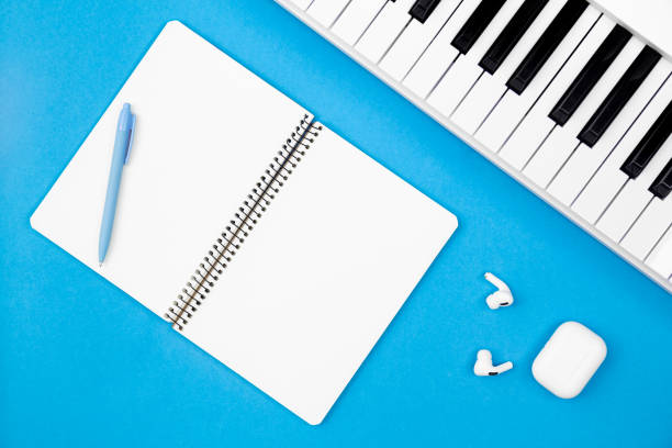 istock Blank notebook and piano on a blue background, flat lay, copy space. 1475328069