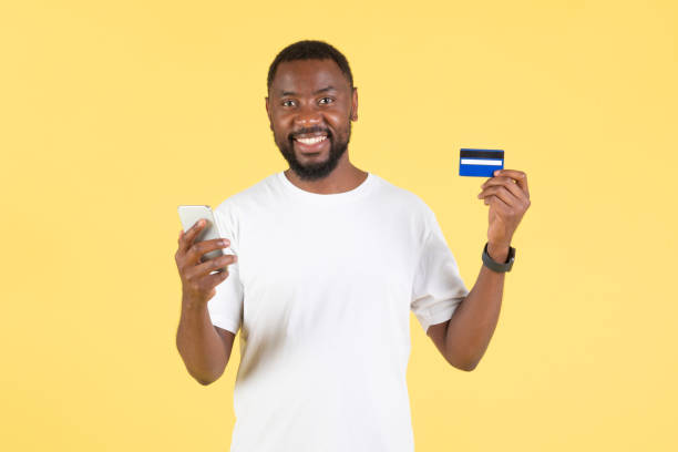 istock African Guy Shopping Via Phone And Credit Card In Studio 1475329073