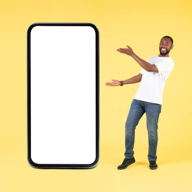 istock Black Guy Showing Big Smartphone With Blank Screen In Studio 1475329085