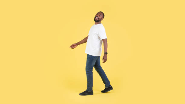 istock Happy Black Male Walking Posing In Studio Over Yellow Background 1475329391