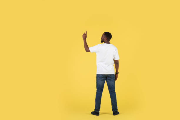 istock African American Man Pointing Finger Pushing Invisible Button, Yellow Background 1475329760
